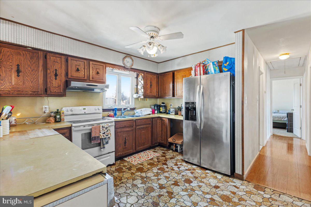 121 Catherine Avenue Buena, NJ 08310 - Photo 15 of 34 a kitchen with a refrigerator a stove a sink dishwasher and a dining table with wooden floor