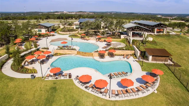 an aerial view of a house with a swimming pool a yard and lake view