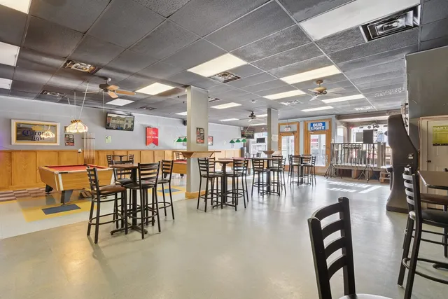 a dining hall with a lots of chairs and wooden floor