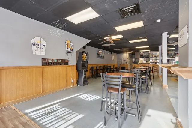 a hallway with painting on the wall and a large mirror