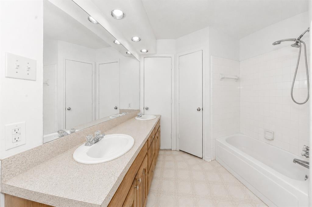 1001 Rosebud Drive Azle, TX 76020 - Photo 28 of 36 Bathroom featuring an extended vanity with dual integrated sinks, laminate countertop, and wood-finish cabinetry