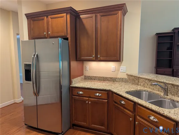 a kitchen with stainless steel appliances granite countertop a refrigerator and a sink