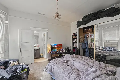 a bed room with a bed window and a mirror