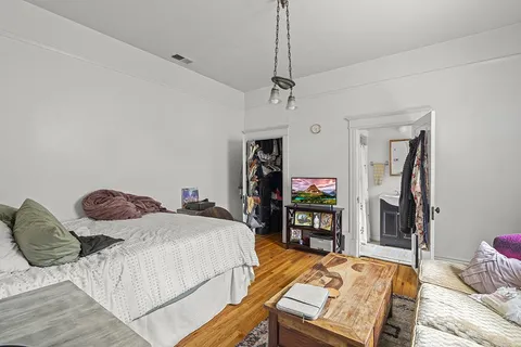 a bedroom with bed and wooden floor
