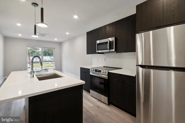 a kitchen with stainless steel appliances a refrigerator sink and microwave