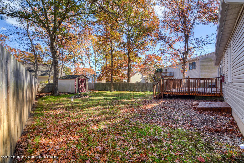 156 Wave Road Manahawkin, NJ 08050 - Photo 17 of 18 a backyard of a house with barbeque oven and trees