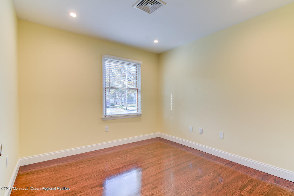 156 Wave Road Manahawkin, NJ 08050 - Photo 10 of 18 an empty room with wooden floor and windows