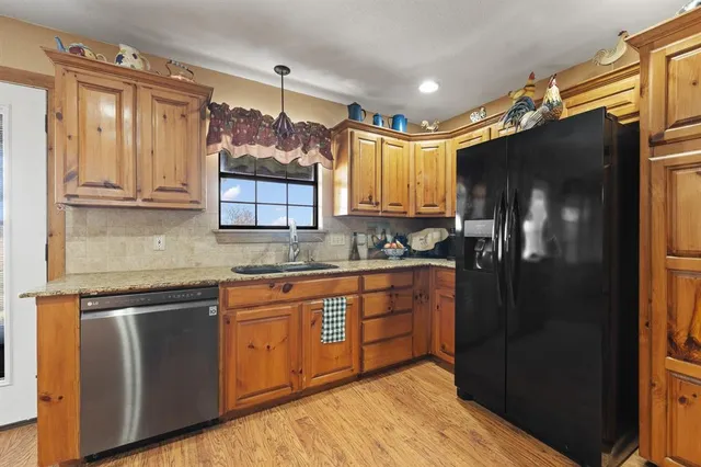 a kitchen with stainless steel appliances granite countertop a refrigerator and a sink