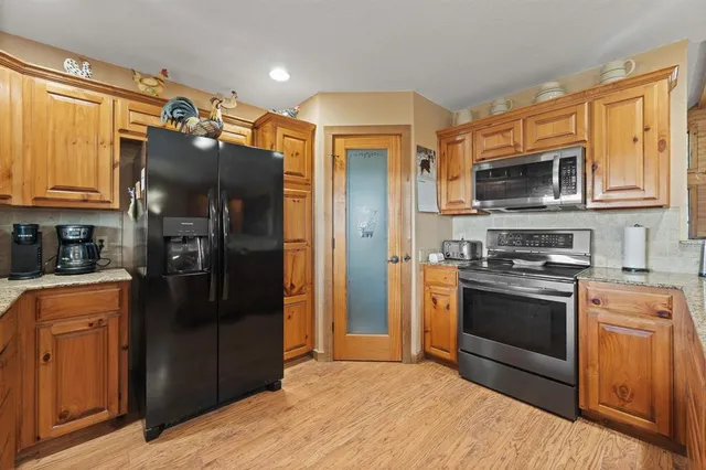 a kitchen with stainless steel appliances granite countertop a refrigerator stove and microwave