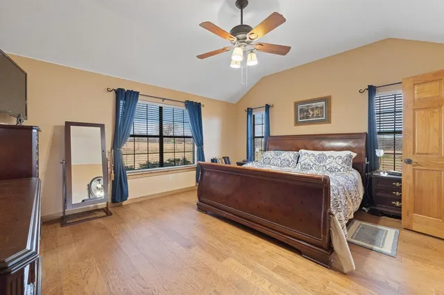 a spacious bedroom with a large bed and a chandelier