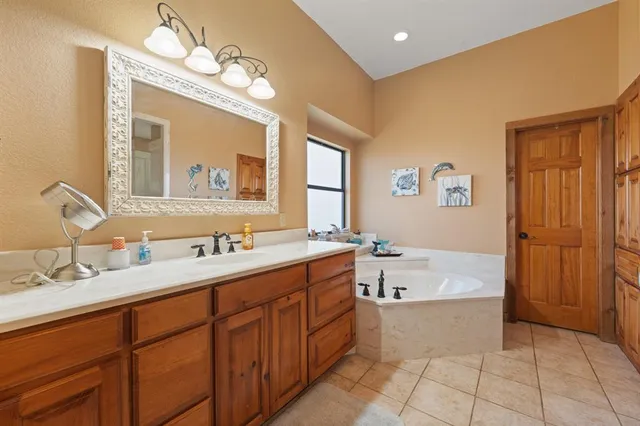 a bathroom with a tub sink and mirror