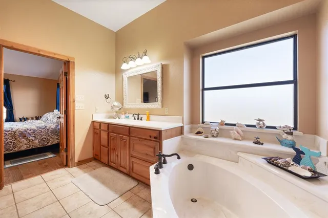 a bathroom with a tub sink and mirror