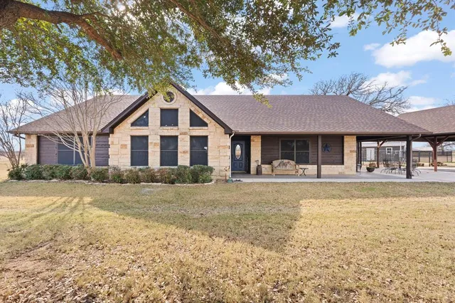 a front view of a house with a yard and trees