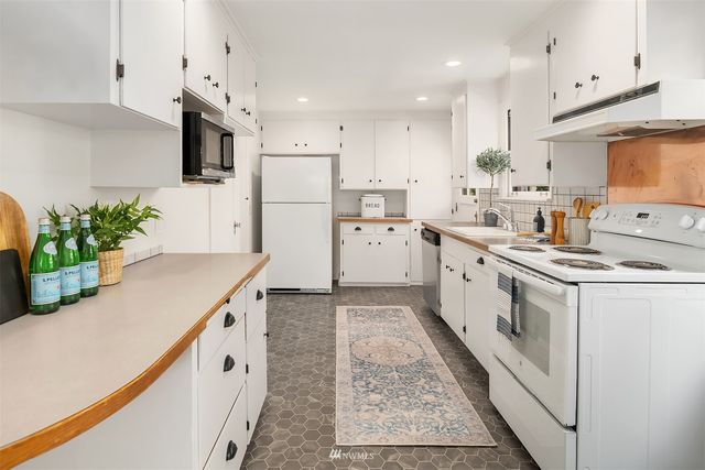 a kitchen with white cabinets and white appliances