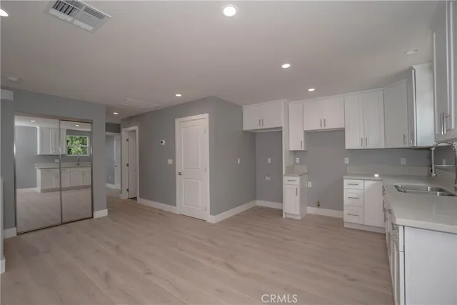 a view of a kitchen with refrigerator and wooden floor