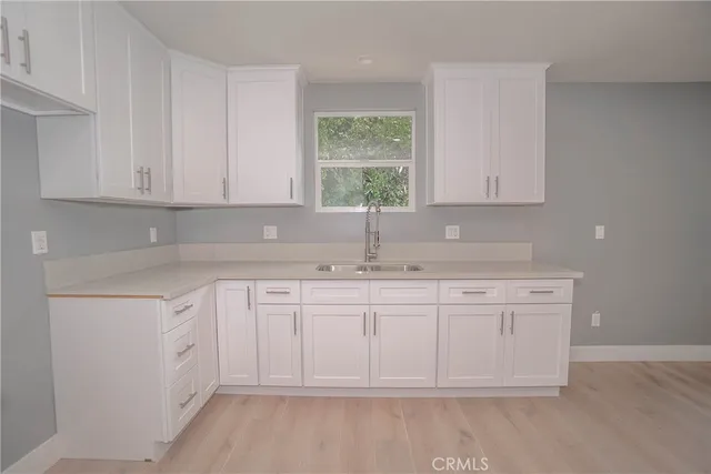 a kitchen with granite countertop white cabinets white appliances and a sink