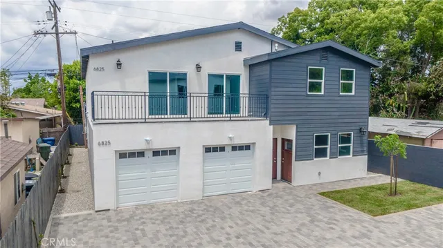 a view of a house with a garage and balcony