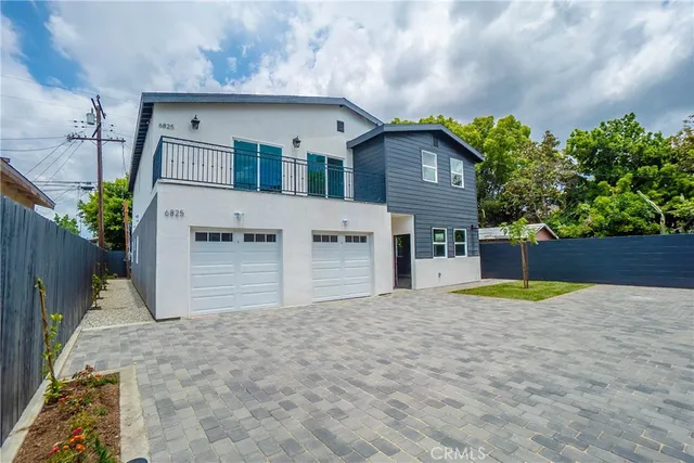 a view of a house with a yard and a large tree