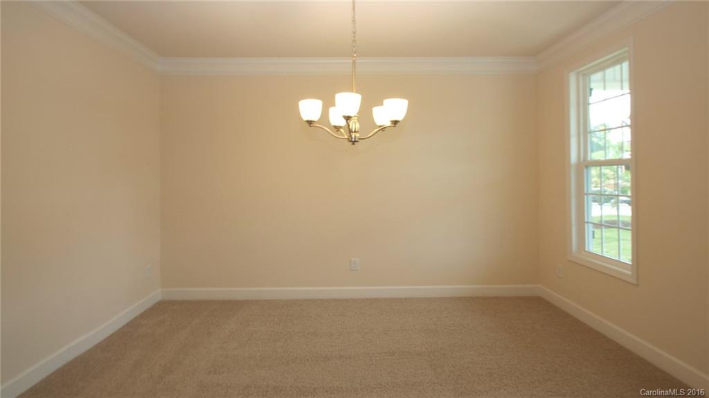 5706 Joshua Cain Road, Unit L0041 Charlotte, NC 28213 - Photo 12 of 23 an empty room with windows and chandelier fan