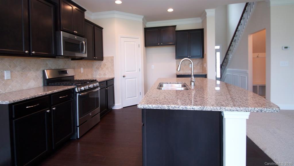 5706 Joshua Cain Road, Unit L0041 Charlotte, NC 28213 - Photo 3 of 23 a kitchen with granite countertop a sink stainless steel appliances and cabinets