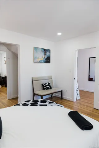 a white bed sitting in a bedroom next to a window