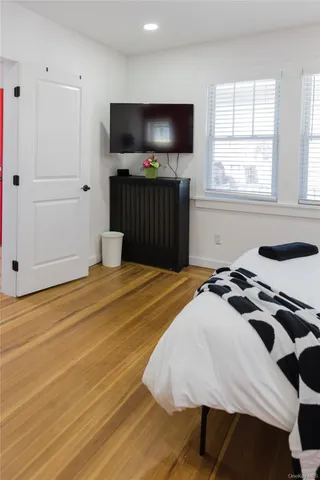 a bedroom with a bed and wooden floor
