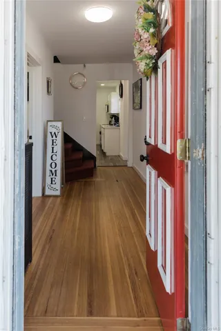 a view of a hallway with wooden floor and staircase