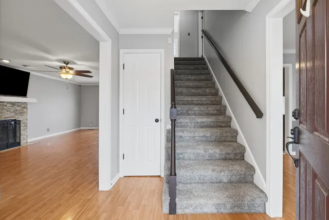a view of a livingroom with wooden floor and staircase