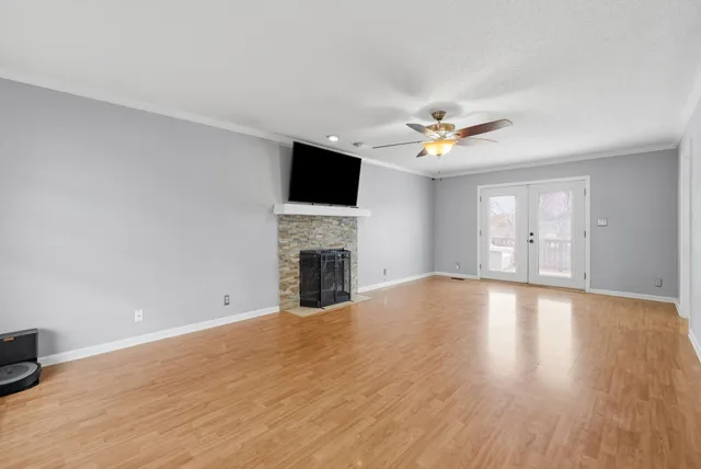 a view of an empty room with a fireplace and a window