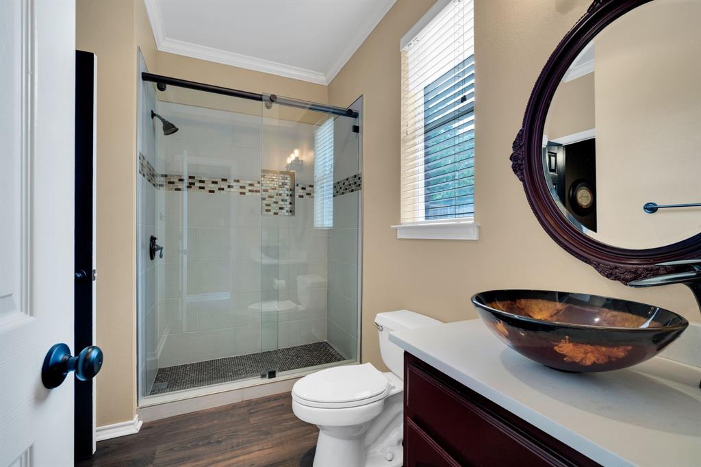 1907 Timber Ridge Court Cedar Hill, TX 75104 - Photo 18 of 30 Bathroom featuring a glass-enclosed shower with tiled walls and a mosaic accent band