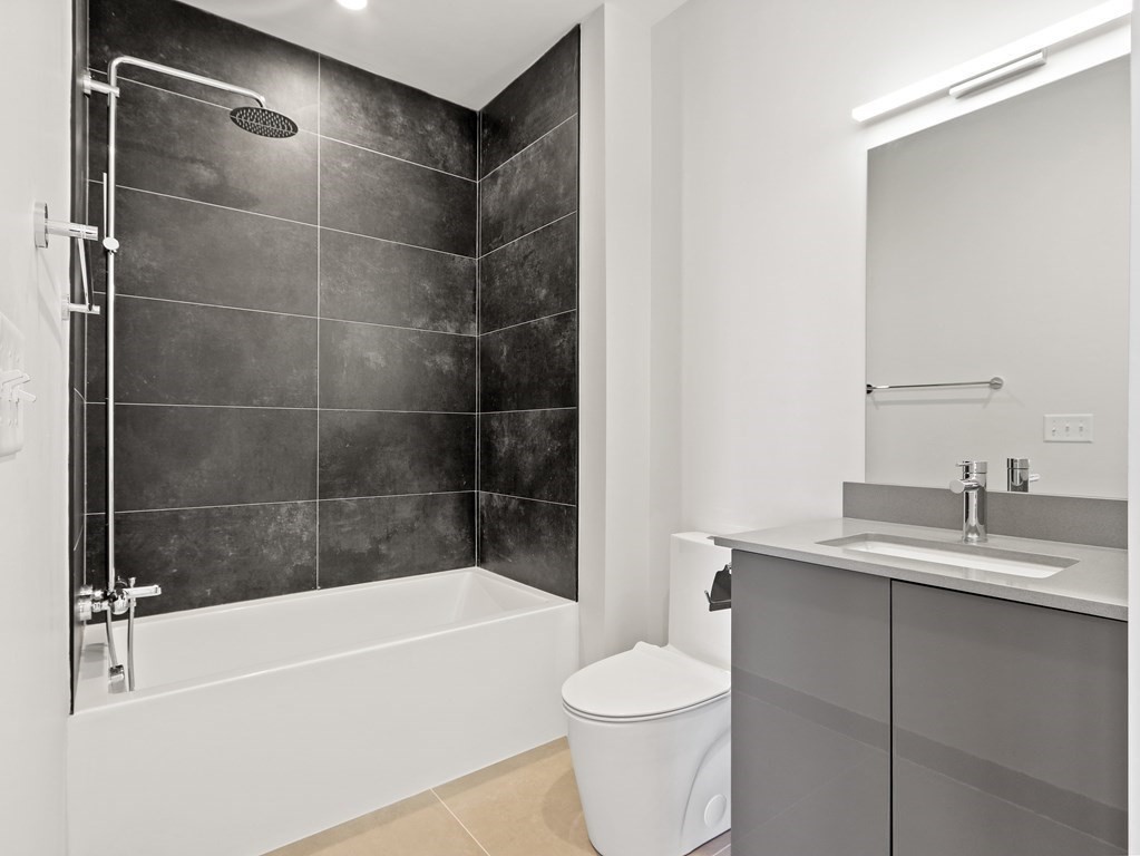 340 West 2nd Street, Unit 8 Boston, MA 02127 - Photo 18 of 38 a bathroom with a bathtub shower sink vanity and toilet