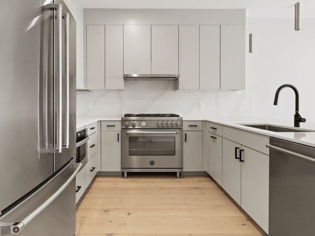 340 West 2nd Street, Unit 8 Boston, MA 02127 - Photo 5 of 38 a kitchen with white cabinets and white appliances