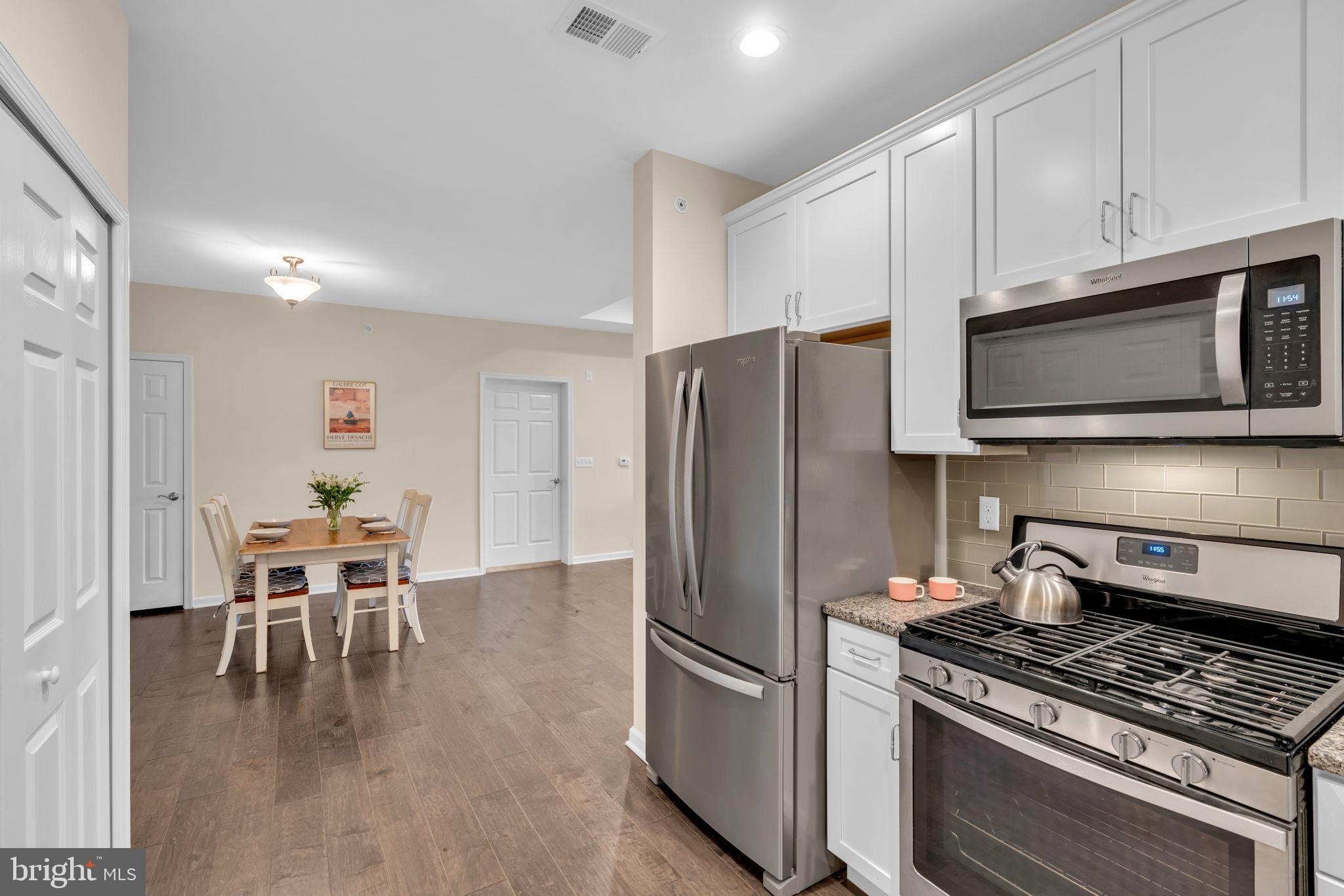 1044 Halifax Place Hamilton, NJ 08619 - Photo 12 of 39 a kitchen with stainless steel appliances a stove a microwave a dining table and chairs