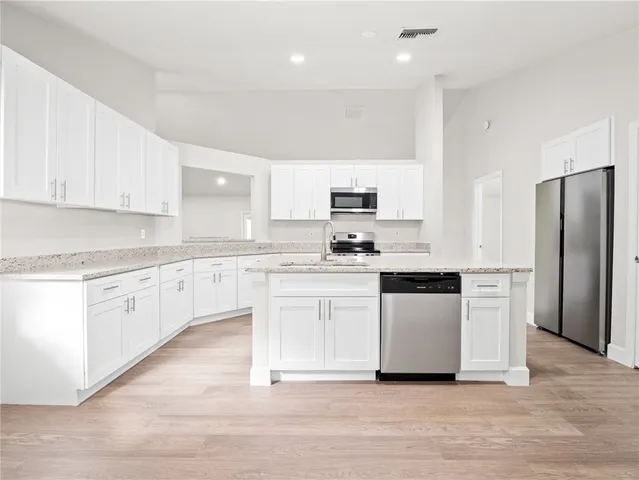 a kitchen with white cabinets stainless steel appliances and sink