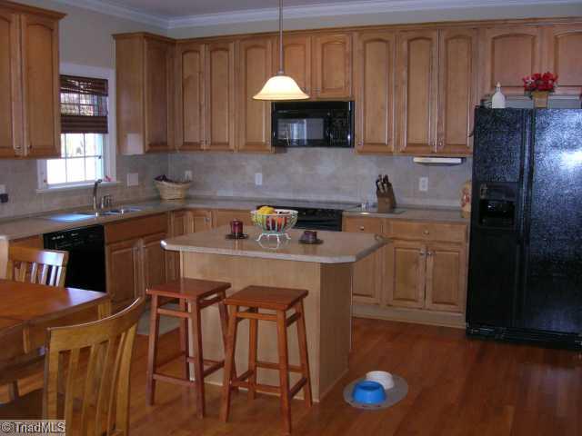 8502 Billet Place Oak Ridge, NC 27310 - Photo 2 of 11 Kitchen. Spacious Kitchen with Granite Countertops and Tile Back Splash. Hardwood flooring.