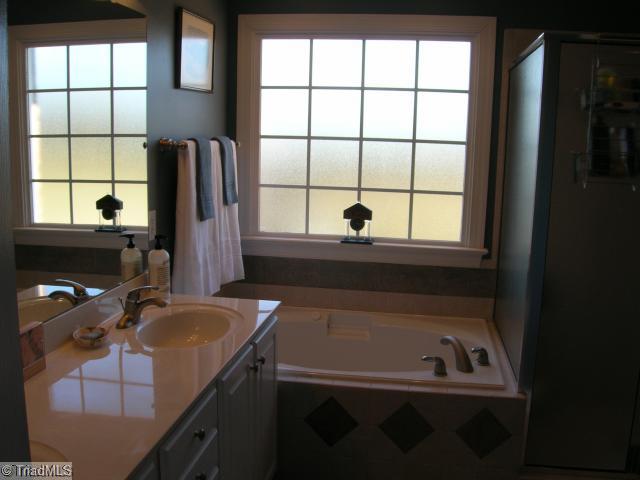 8502 Billet Place Oak Ridge, NC 27310 - Photo 8 of 11 Other. Master Bathroom with double sinks, jetted tub, tile floor and tile surround on tub, frosted window.