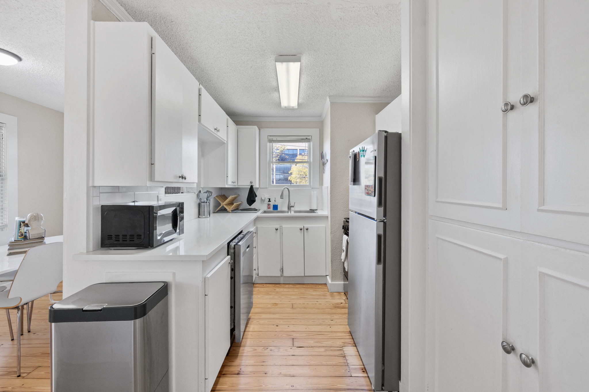 1202 East 29th Street, Unit A Austin, TX 78722 - Photo 12 of 37 a kitchen with white cabinets and stainless steel appliances