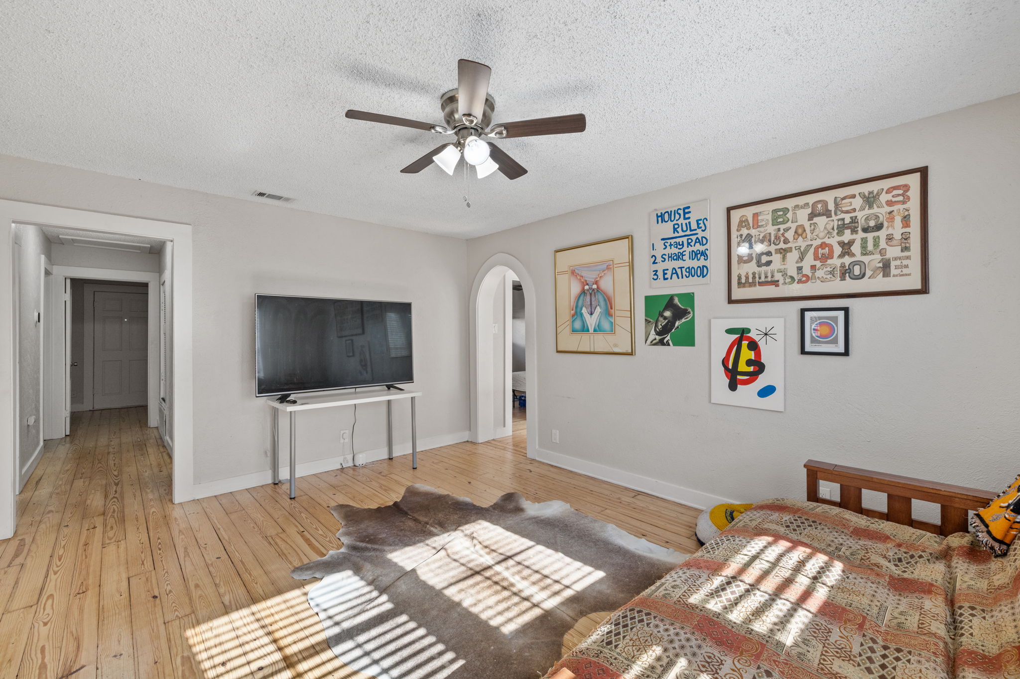 1202 East 29th Street, Unit A Austin, TX 78722 - Photo 8 of 37 a living room with a bed and a flat screen tv