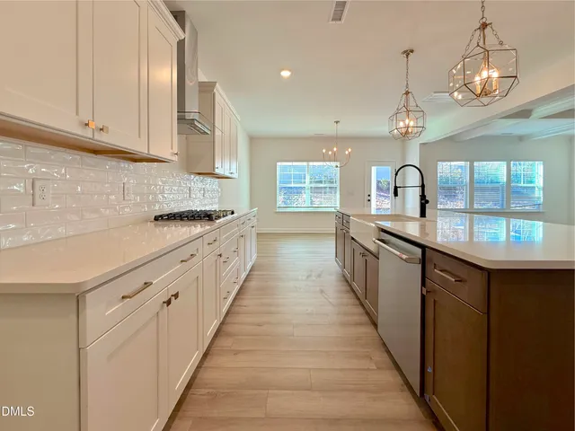 a large kitchen with stainless steel appliances lots of counter space and wooden floor