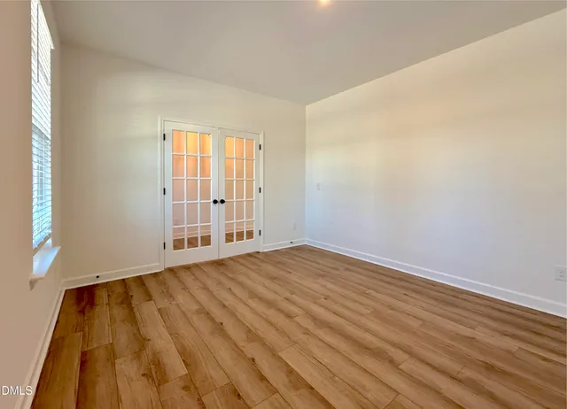 an empty room with wooden floor and cabinet