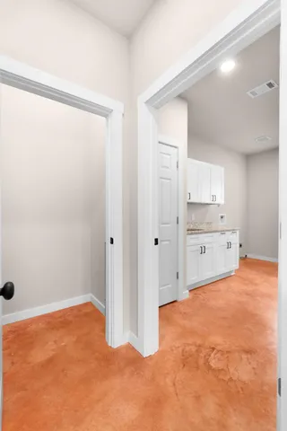 a view of an empty room with cabinet and a window