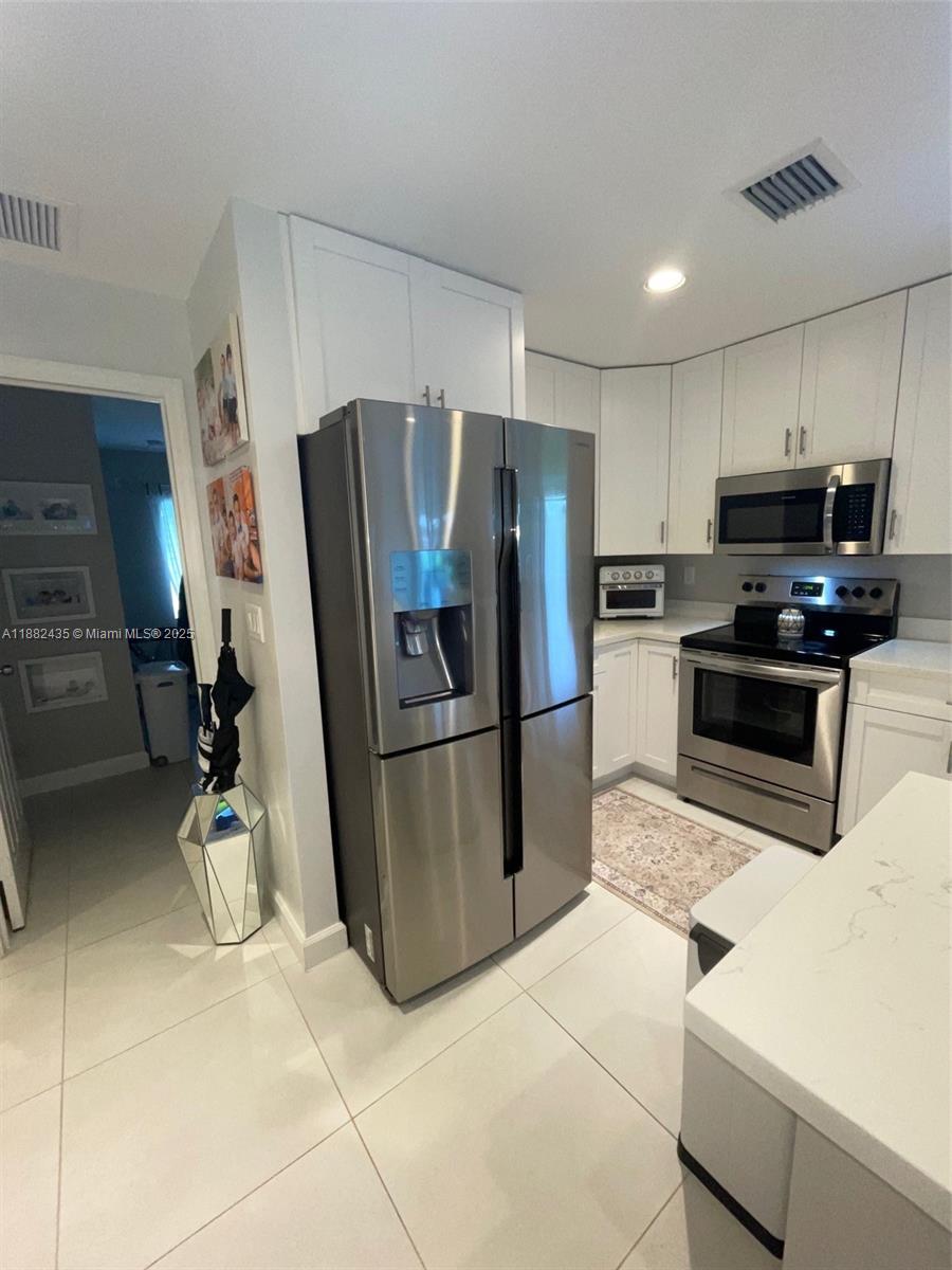 20605 Southwest 319th Street Homestead, FL 33030 - Photo 18 of 67 a kitchen with stainless steel appliances a refrigerator a stove a sink a washer and dryer