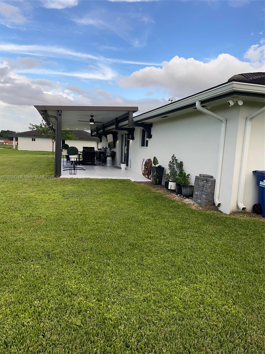 20605 Southwest 319th Street Homestead, FL 33030 - Photo 55 of 67 a view of a patio with table and chairs a barbeque