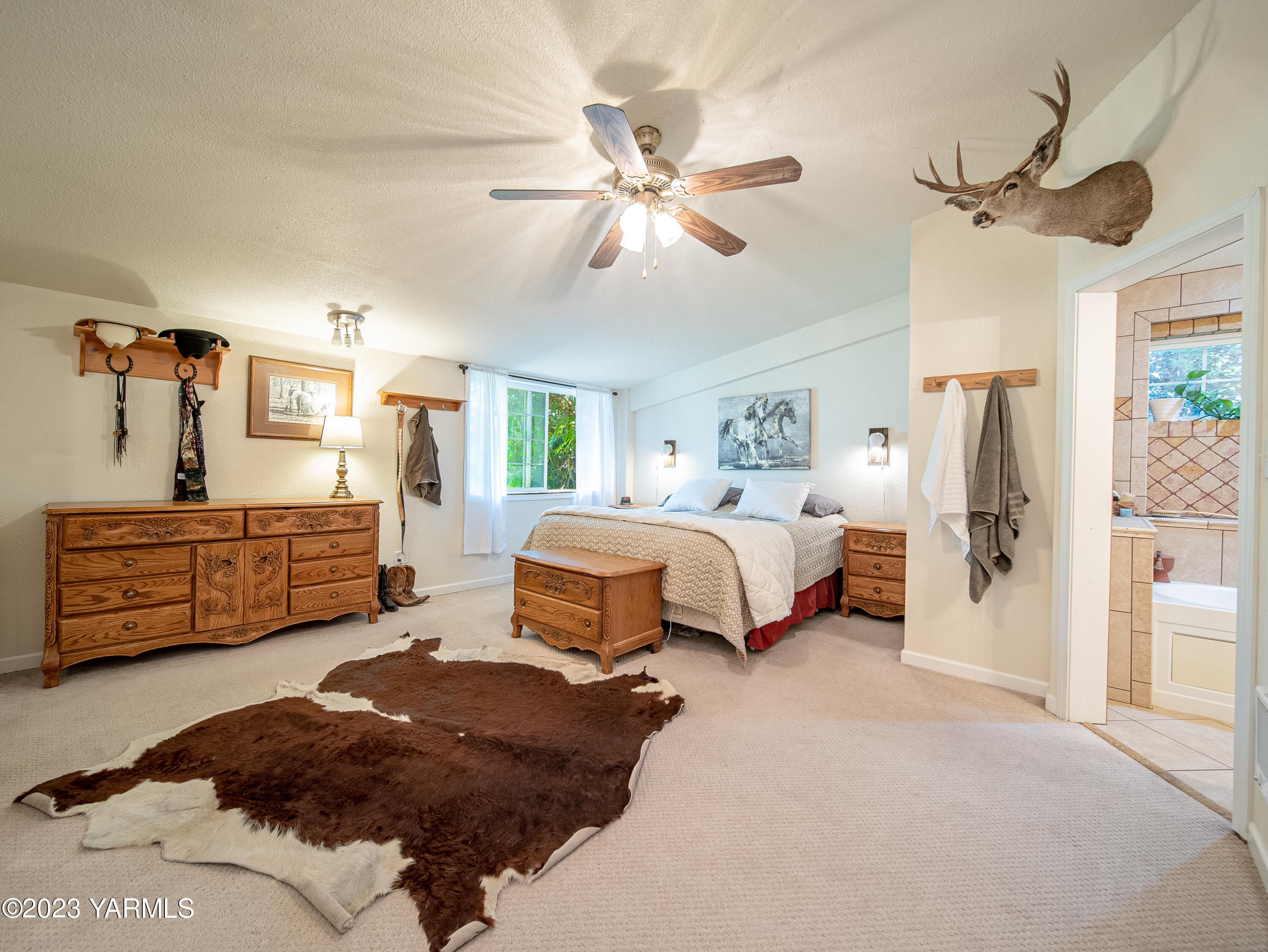 109004 King Tull Road Prosser, WA 99350 - Photo 24 of 49 a bedroom with a bed a chandelier and dresser