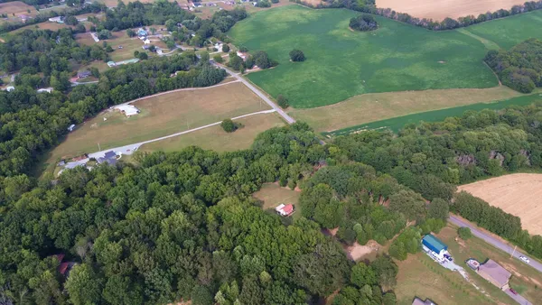 a view of a green field with wooden fence