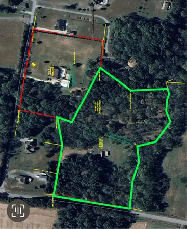 an aerial view of residential houses with outdoor space and trees
