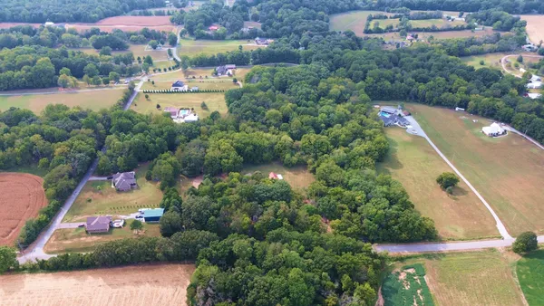 an aerial view of a house with a yard and lake view