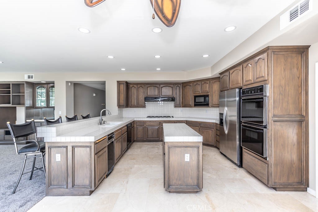 2871 North Roxbury Street Orange, CA 92867 - Photo 14 of 25 a large kitchen with stainless steel appliances kitchen island granite countertop a large counter top stainless steel appliances and cabinets