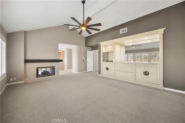 a view of an empty room with a fireplace and a window