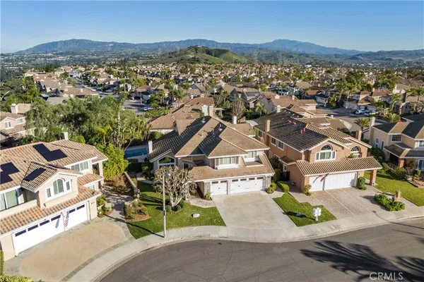 an aerial view of a house with a mountain